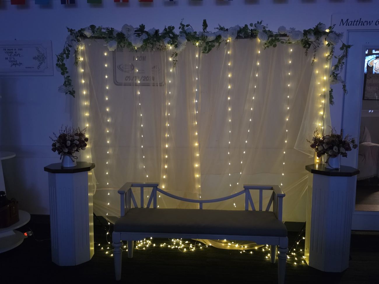 White bench with a string-light backdrop