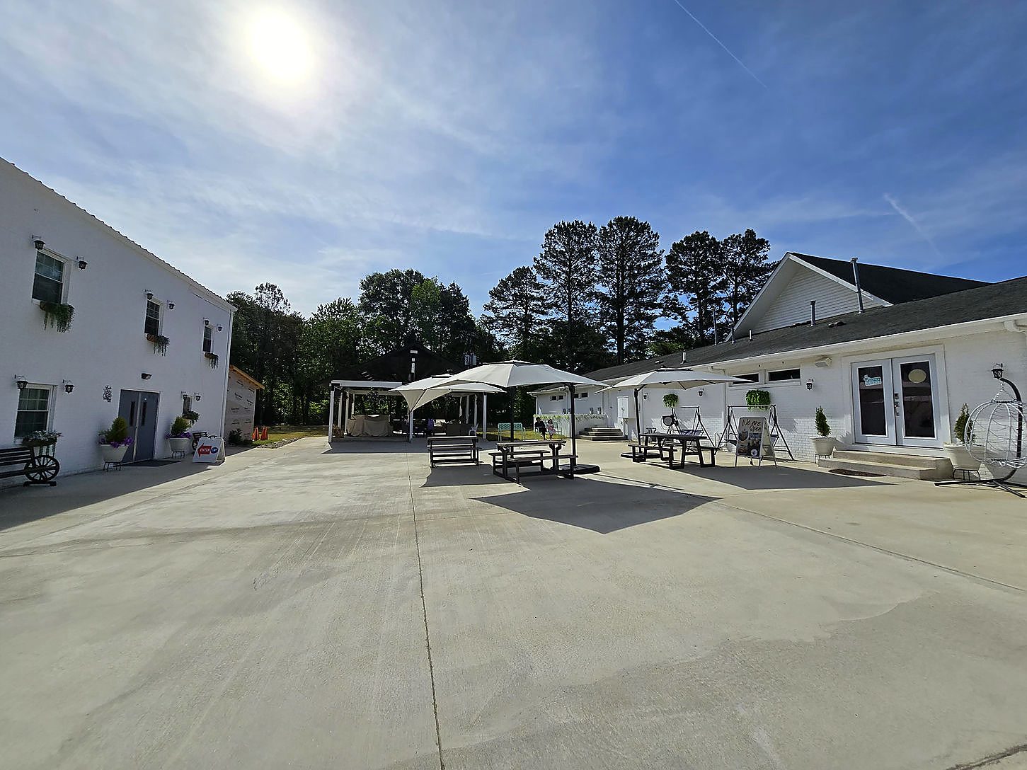 Outdoor courtyard with tables and umbrellas, and the pavilion behind